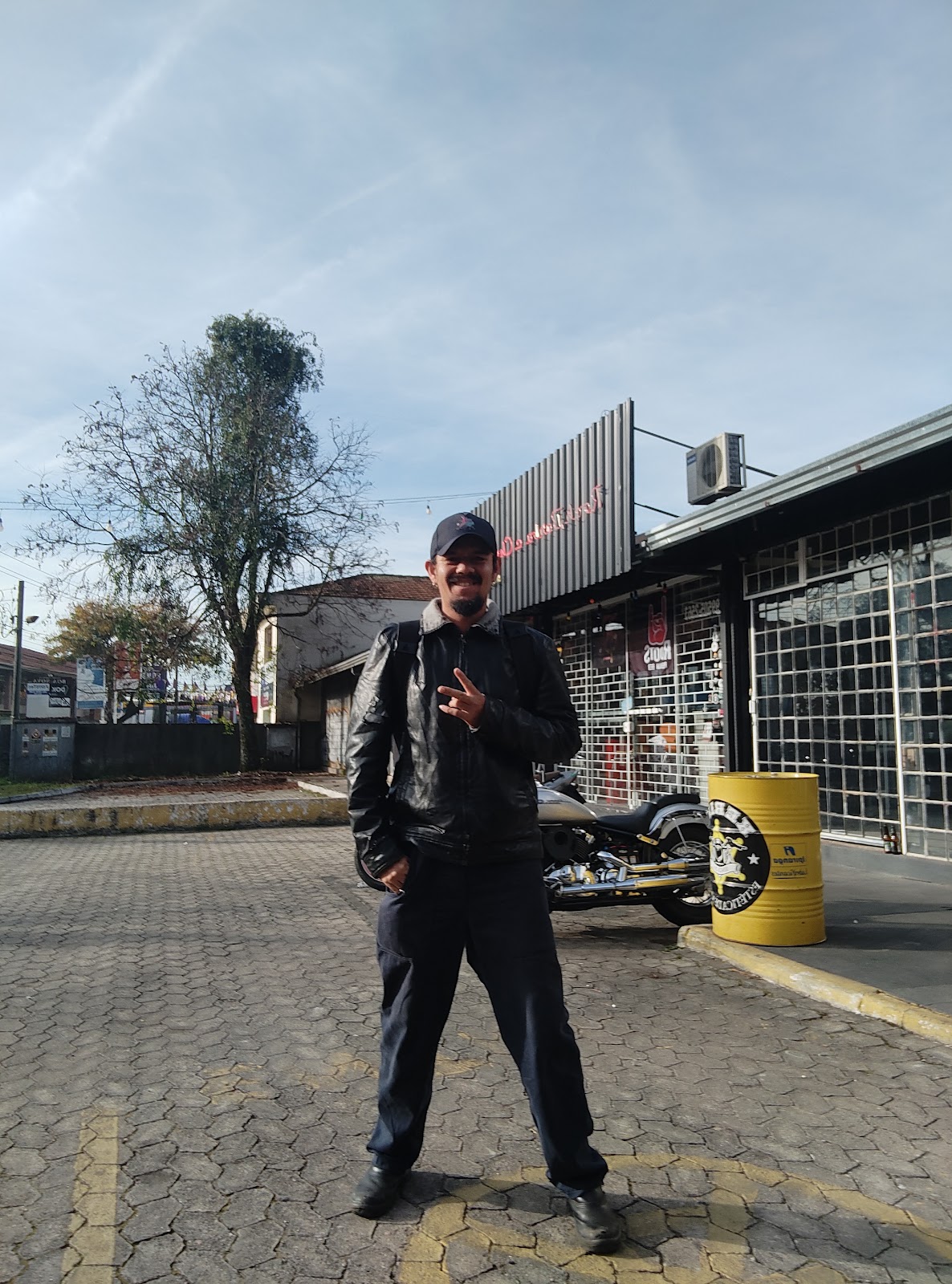 Cliente em frente à fachada da barbearia